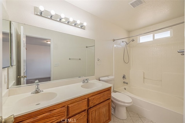 full bathroom with a textured ceiling, vanity, tile patterned flooring, toilet, and tiled shower / bath