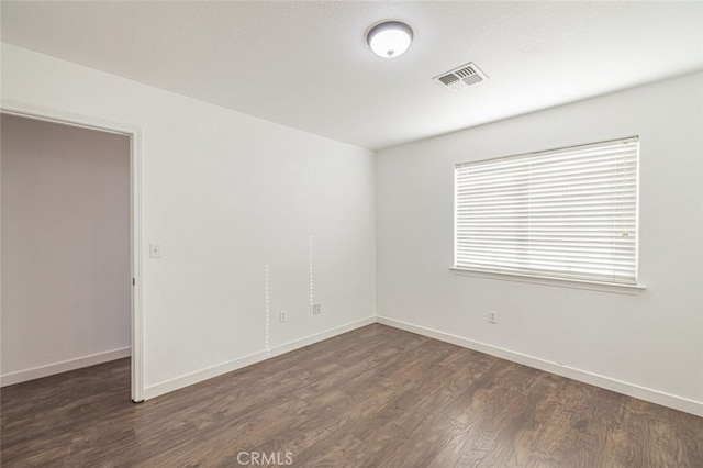 spare room with dark wood-type flooring