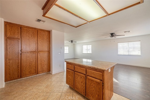 kitchen featuring ceiling fan, a kitchen island, and a wealth of natural light