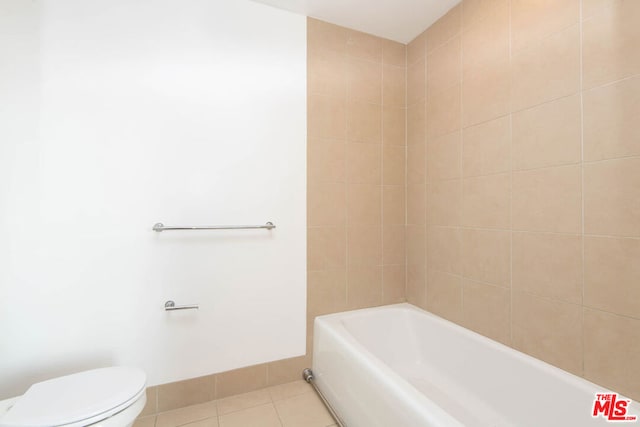 bathroom with toilet, tile patterned floors, and a tub