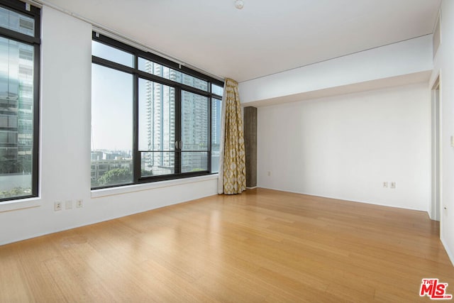 unfurnished room with hardwood / wood-style flooring