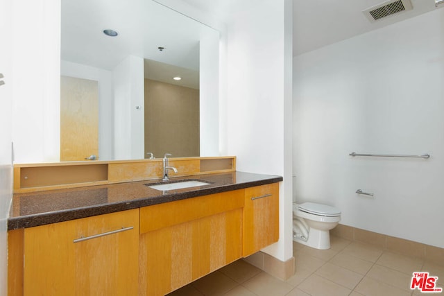 bathroom featuring tile patterned flooring, vanity, and toilet