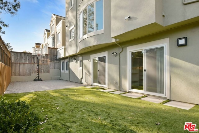 back of house with a patio area and a yard