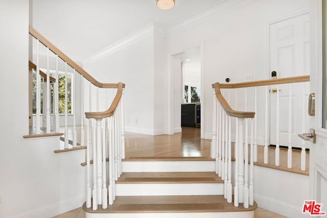 stairs featuring tile patterned flooring and crown molding