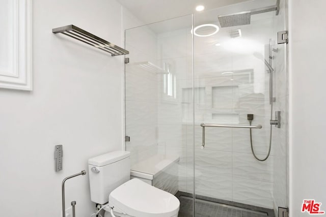 bathroom featuring toilet and a shower with door