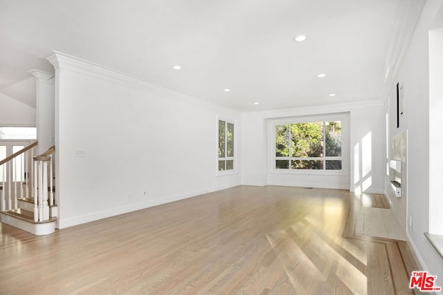 unfurnished living room featuring crown molding and light hardwood / wood-style flooring