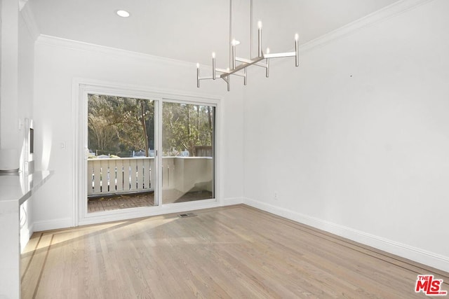 unfurnished dining area with hardwood / wood-style flooring, a notable chandelier, and ornamental molding