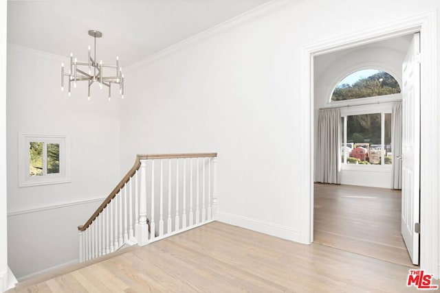 foyer entrance featuring a chandelier, light hardwood / wood-style floors, and crown molding