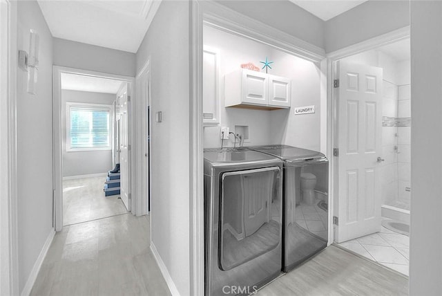 laundry room featuring cabinets and washing machine and clothes dryer