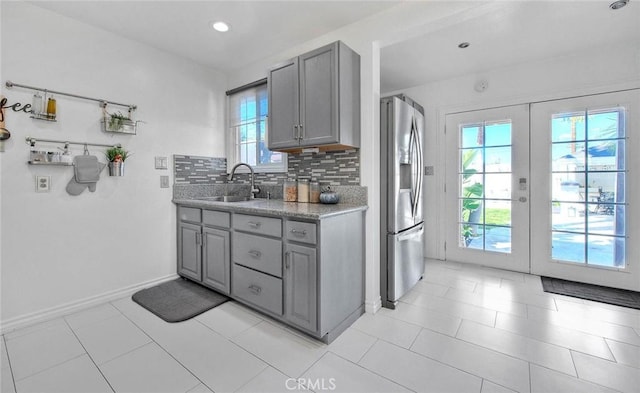 kitchen with stainless steel fridge, gray cabinets, plenty of natural light, and sink