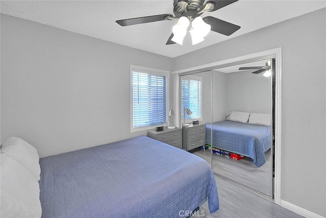 bedroom featuring ceiling fan, a closet, and light hardwood / wood-style floors