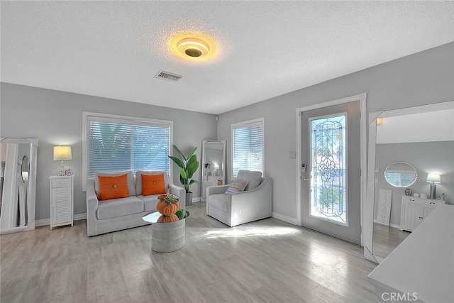 living room featuring light hardwood / wood-style flooring and a textured ceiling