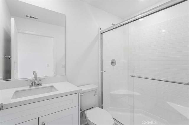 bathroom with toilet, a shower stall, visible vents, and vanity