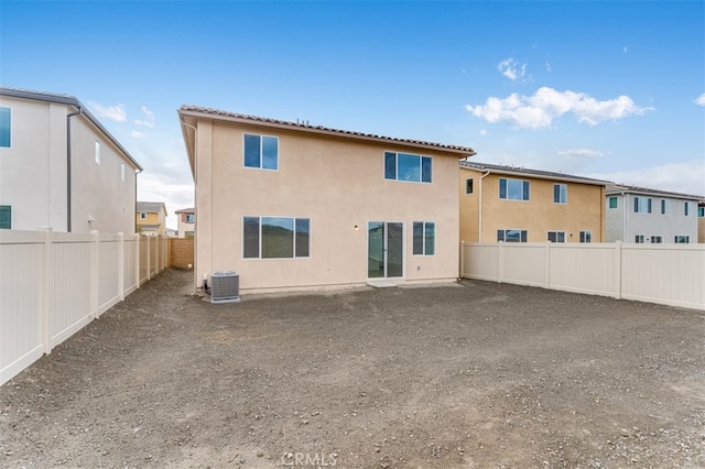 rear view of property with a fenced backyard, a tiled roof, and stucco siding