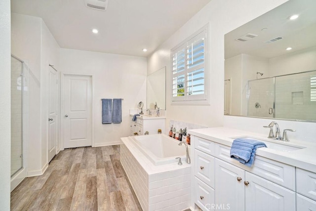 bathroom featuring hardwood / wood-style floors, vanity, and shower with separate bathtub