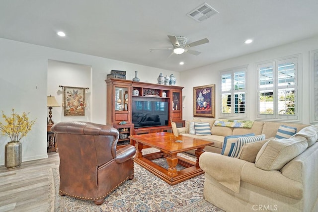 living room featuring ceiling fan and light hardwood / wood-style floors