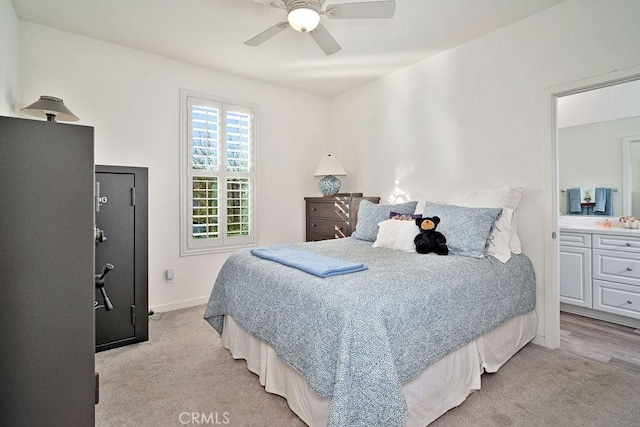 bedroom featuring connected bathroom, ceiling fan, and light carpet