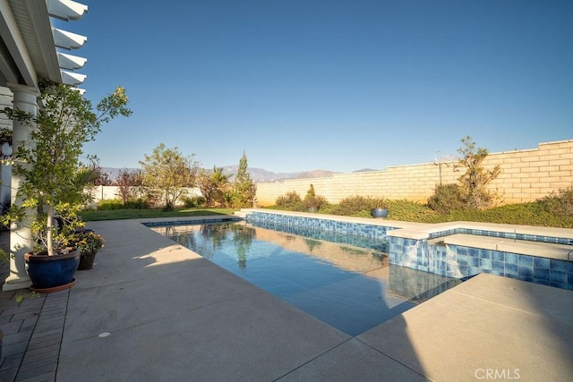 view of swimming pool featuring a mountain view and an in ground hot tub