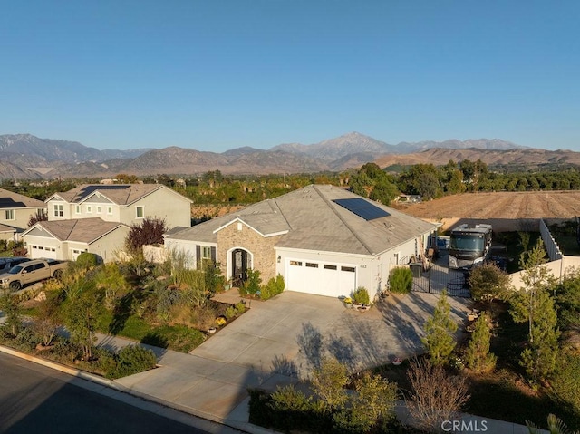 view of front of house featuring a mountain view, solar panels, and a garage