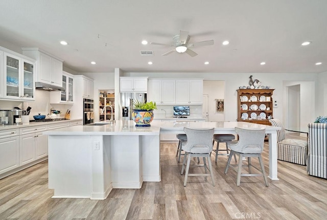 kitchen with a kitchen bar, a large island, and light hardwood / wood-style floors