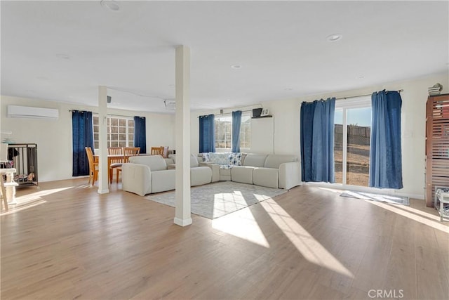 unfurnished living room featuring light wood finished floors, a wall mounted air conditioner, and recessed lighting