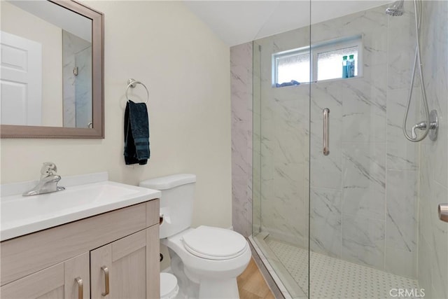 full bathroom with a marble finish shower, vanity, and toilet