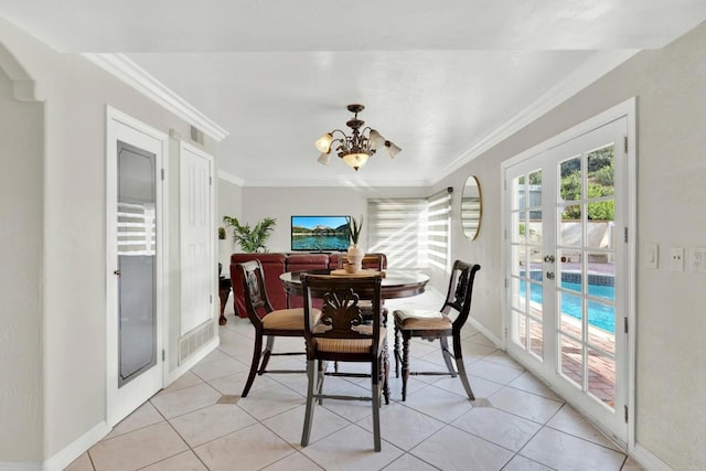 dining area with an inviting chandelier, light tile patterned floors, crown molding, and french doors