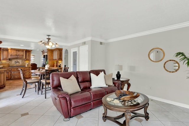 tiled living room featuring crown molding and an inviting chandelier