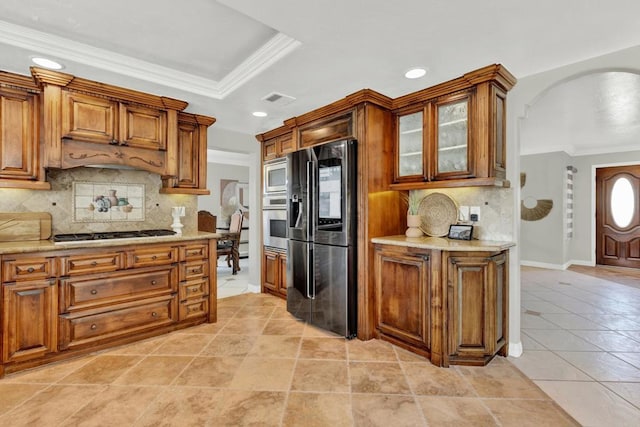 kitchen with backsplash, ornamental molding, and appliances with stainless steel finishes