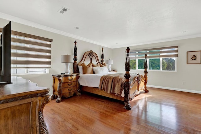 bedroom with light hardwood / wood-style flooring and crown molding