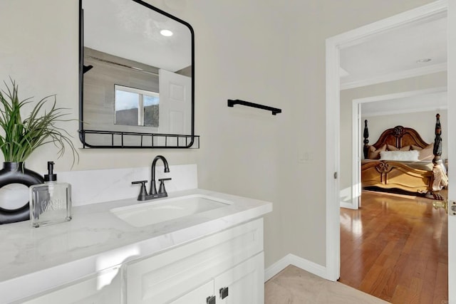 bathroom with vanity, hardwood / wood-style flooring, and crown molding