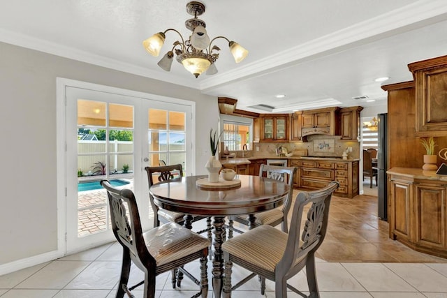 tiled dining room with sink, french doors, a chandelier, and ornamental molding