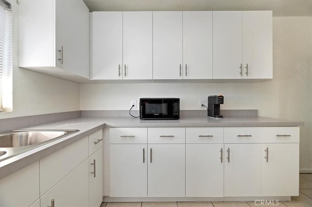 kitchen with white cabinets and light tile patterned floors