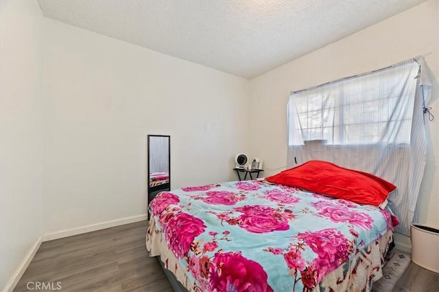 bedroom with a textured ceiling and dark wood-type flooring