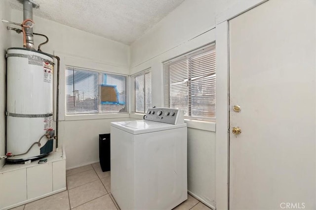 laundry area featuring light tile patterned floors, strapped water heater, a textured ceiling, and washer / dryer