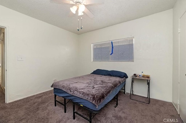 carpeted bedroom featuring ceiling fan and a textured ceiling