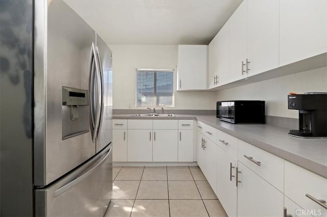 kitchen featuring white cabinets, stainless steel fridge with ice dispenser, sink, and light tile patterned floors