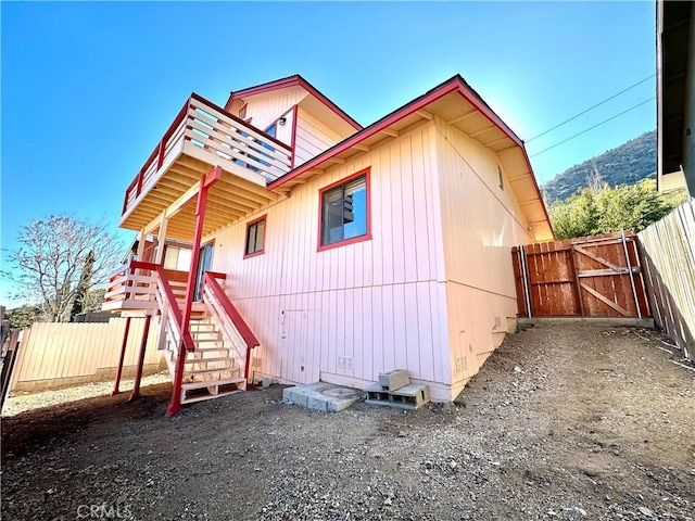 back of house with a gate, stairway, and fence