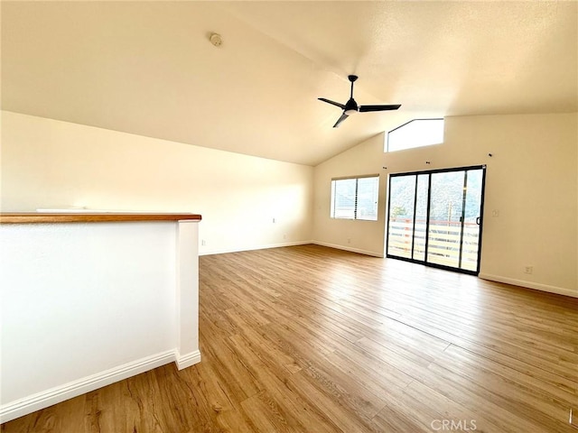 unfurnished room with baseboards, lofted ceiling, light wood-style flooring, and a ceiling fan