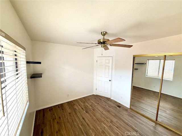 unfurnished bedroom with visible vents, wood finished floors, a closet, baseboards, and ceiling fan