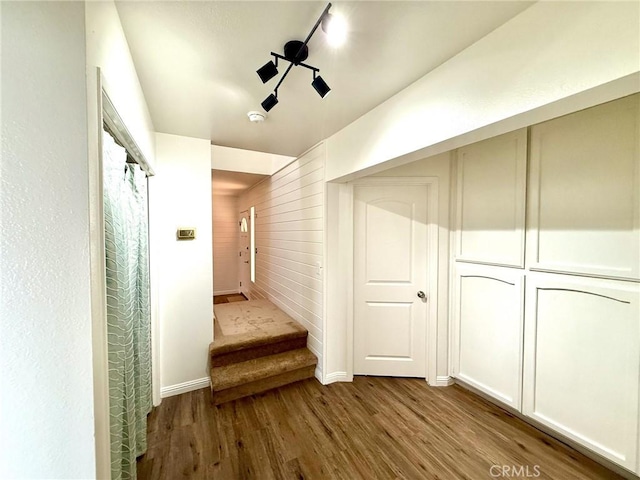 corridor with track lighting, stairway, and wood finished floors