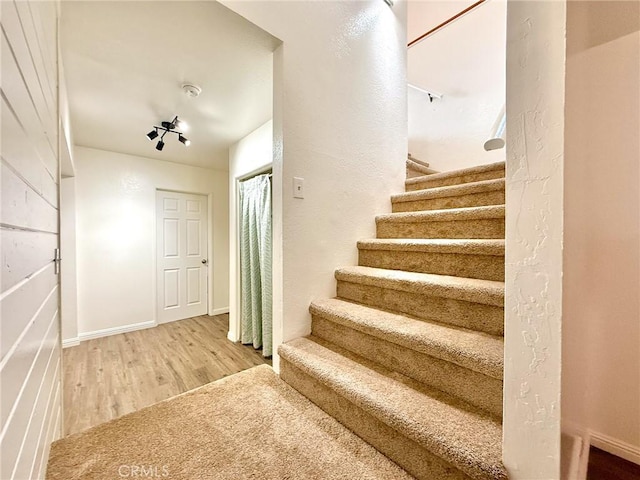 stairway with baseboards and wood finished floors