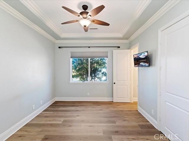 empty room featuring crown molding, ceiling fan, and light wood-type flooring