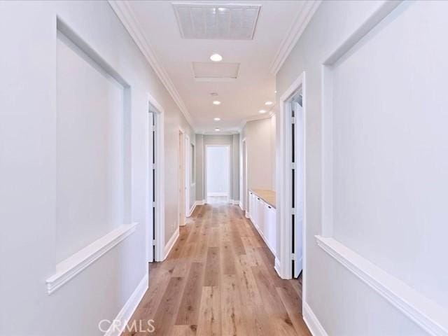 corridor featuring ornamental molding and light hardwood / wood-style flooring