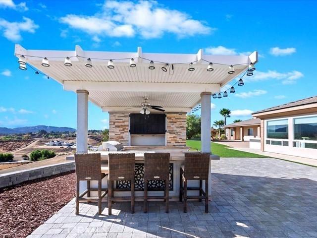 view of patio with a bar, a mountain view, and ceiling fan