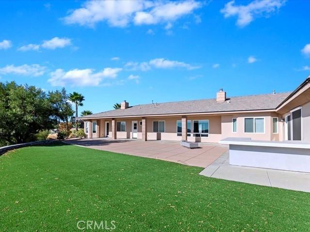 back of house with a yard and a patio area