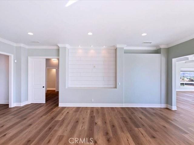 spare room with ornamental molding and dark hardwood / wood-style floors