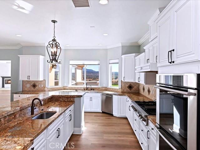 kitchen featuring sink, stainless steel appliances, dark stone counters, and white cabinets