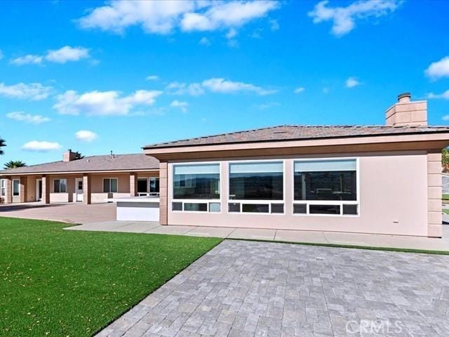 back of property featuring a yard and a patio