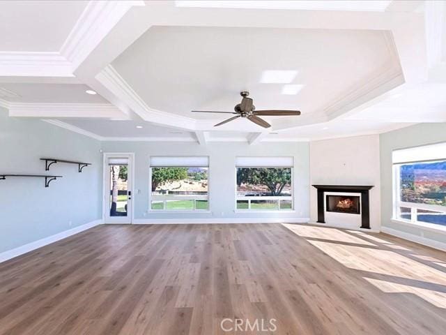 unfurnished living room featuring hardwood / wood-style floors, beam ceiling, ornamental molding, and ceiling fan